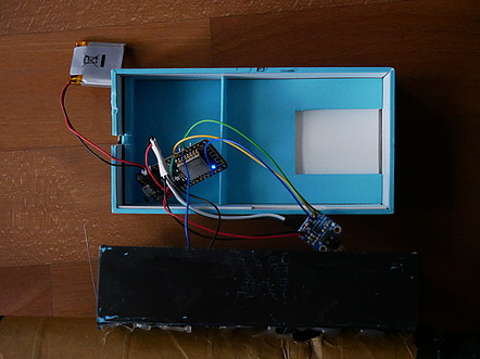 Die Pappschachtel (ein alter Smartphone-Karton) beherbergt neben dem Tastschalter das Microcontroller-Board, einen kleinen Lithium-Akku und das I2S-Audio-Board